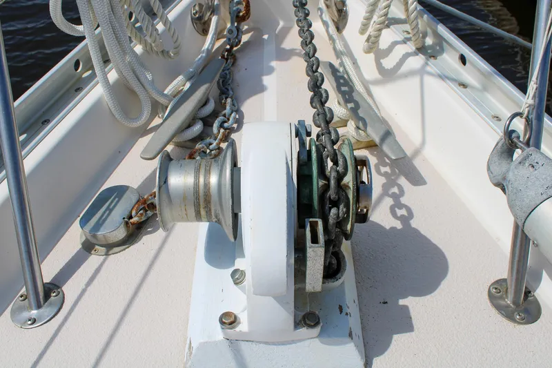Slide: The Image of Anchor windlass on 1989 Morgan 44 Center Cockpit sailboat deck with ropes and chains. - 35