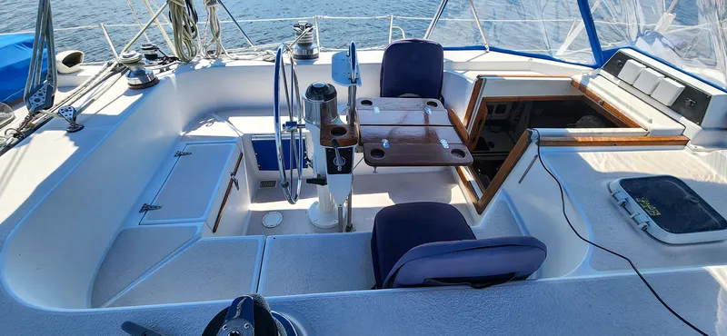 Slide: The Image of 1989 Morgan 44 Center Cockpit sailboat interior with seating, table, and steering wheel. - 38