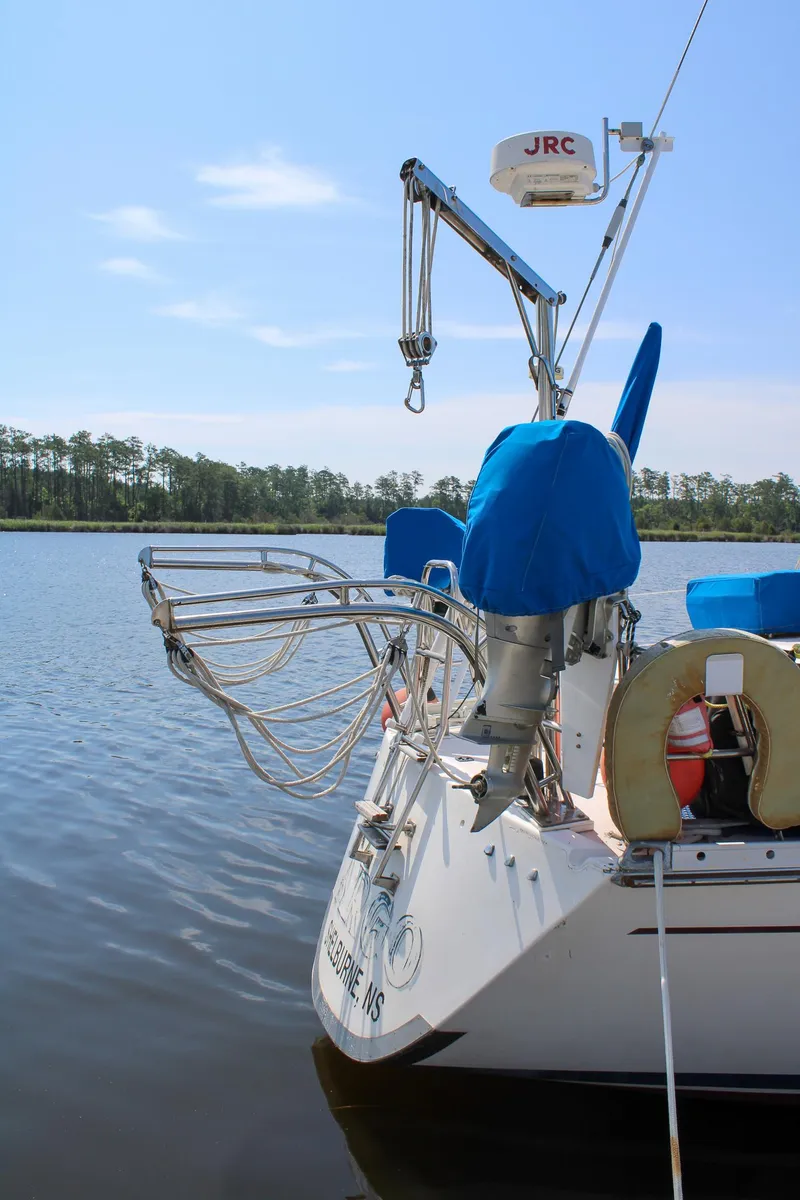 Slide: The Image of 1989 Morgan 44 Center Cockpit sailboat on calm water with blue covers and equipment. - 43