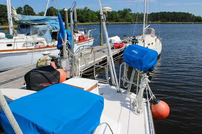 Slide: The Image of 1989 Morgan 44 Center Cockpit sailboat docked at a marina with blue covers. - 44