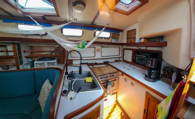 Slide: The Image of Interior of 1989 Morgan 44 Center Cockpit yacht with kitchen and seating area. - 48