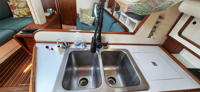 Slide: The Image of 1989 Morgan 44 Center Cockpit kitchen with dual sinks and cozy seating area. - 49