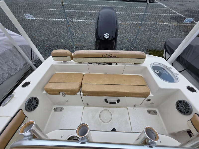 Slide: The Image of 2023 Sea Chaser 22 HFC boat interior with tan seating and Suzuki outboard motor. - 16