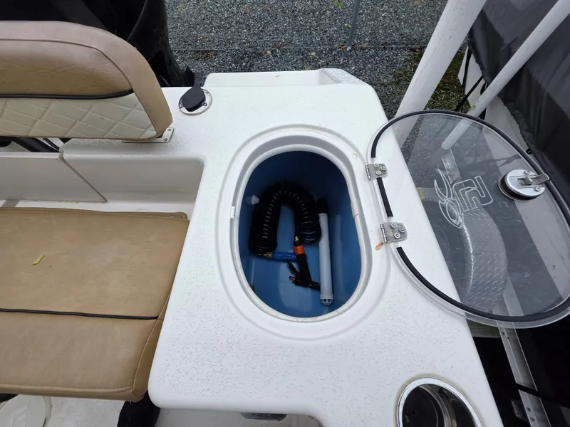 Slide: The Image of 2023 Sea Chaser 22 HFC boat with open storage compartment and beige seating. - 17