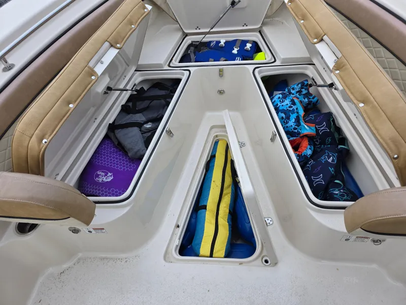 Slide: The Image of 2023 Sea Chaser 22 HFC boat storage compartments with life jackets and gear. - 23