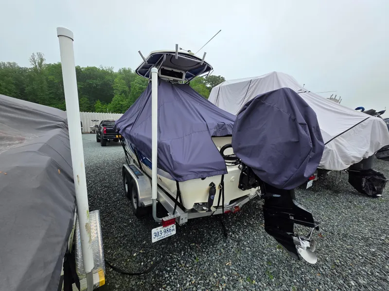 Slide: The Image of 2023 Sea Chaser 22 HFC boat covered and parked on a gravel lot. - 6