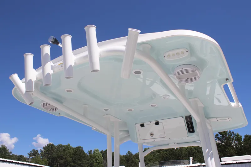 Slide: The Image of 2025 Sea Pro 222 boat top view with rod holders and speakers against blue sky. - 22