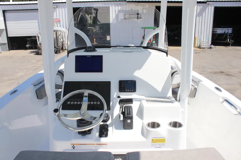 Slide: The Image of 2025 Sea Pro 222 boat console with steering wheel, navigation screens, and cup holders. - 31