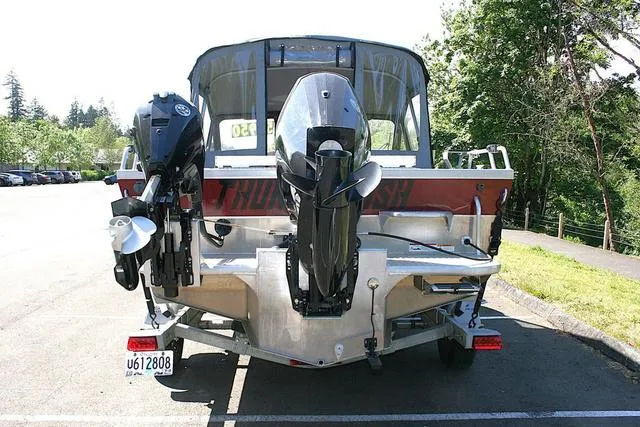 Slide: The Image of 2023 Thunder Jet 185 Luxor boat, rear view with dual outboard motors, parked outdoors. - 4