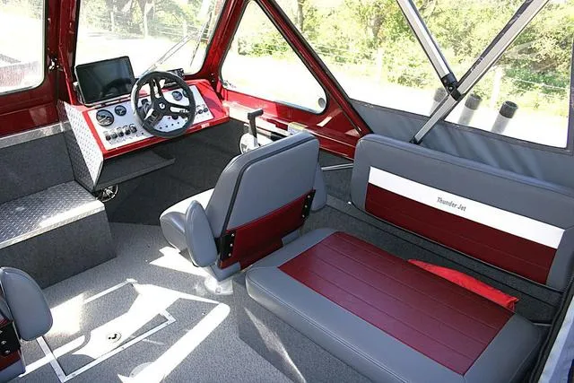 Slide: The Image of 2023 Thunder Jet 185 Luxor boat interior with red and gray seating and modern dashboard. - 7