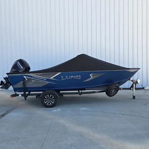 Slide: The Image of 2025 Lund 1775 Adventure Sport boat with cover on trailer, parked outdoors. - 5