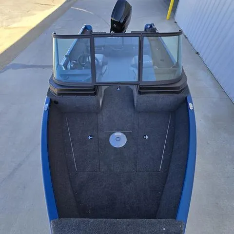 Slide: The Image of 2025 Lund 1775 Adventure Sport boat, blue exterior, spacious deck, windshield, parked on concrete. - 6