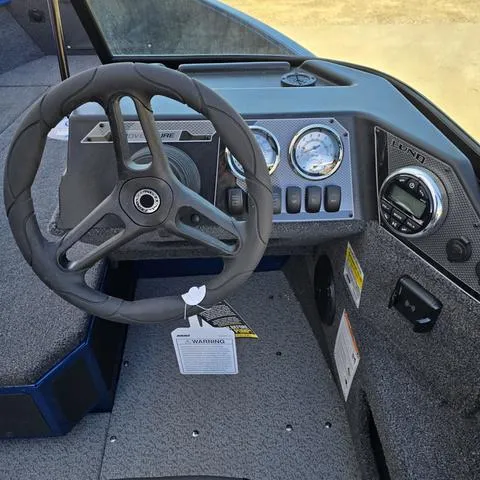 Slide: The Image of 2025 Lund 1775 Adventure Sport boat dashboard with steering wheel and gauges. - 9