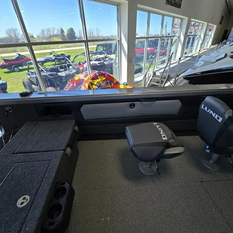 Slide: The Image of 2024 Lund 2075 Tyee boat interior with seating and storage, showroom display. - 12