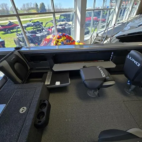 Slide: The Image of 2024 Lund 2075 Tyee boat interior with seating and storage, showroom display. - 13