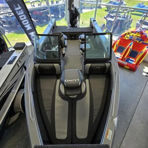 Slide: The Image of 2024 Lund 2075 Tyee boat interior, showroom display with seating and windshield. - 3