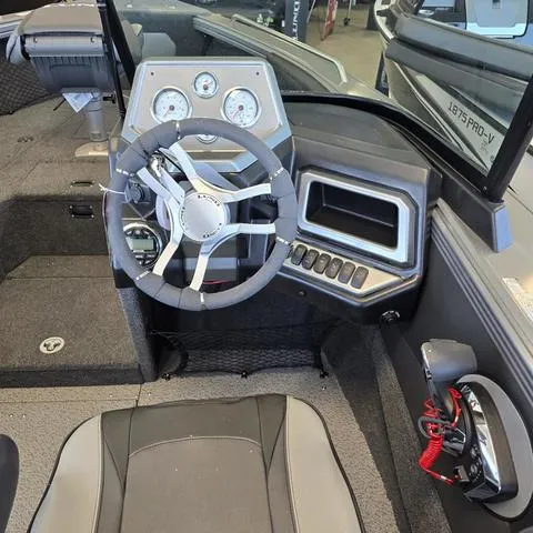 Slide: The Image of 2024 Lund 2075 Tyee boat interior with steering wheel and control panel. - 6