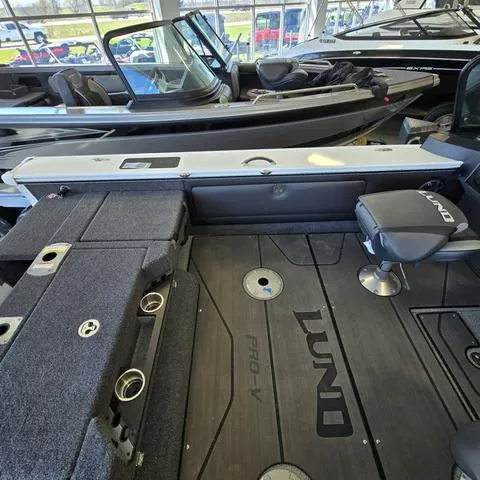 Slide: The Image of 2024 Lund 1875 Pro V Sport boat interior with seating and storage compartments. - 13