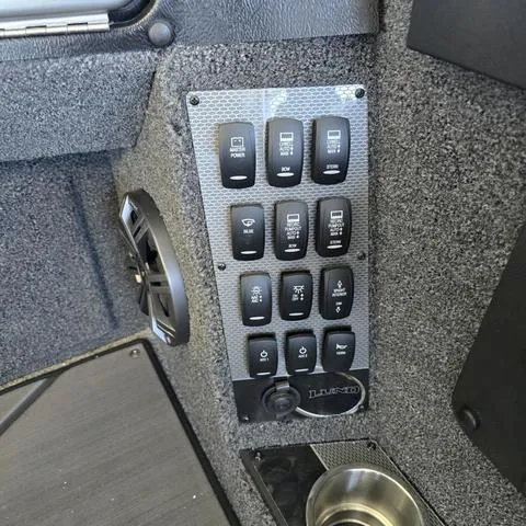 Slide: The Image of Control panel of 2024 Lund 1875 Pro V Sport boat with various switches. - 9