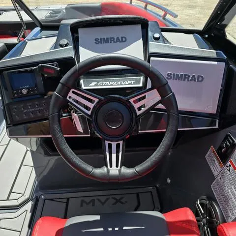 Slide: The Image of 2024 Starcraft MVX IO SURF boat dashboard with Simrad displays and steering wheel. - 11