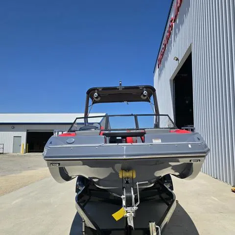Slide: The Image of 2024 Starcraft MVX IO SURF boat on trailer outside a warehouse. - 2