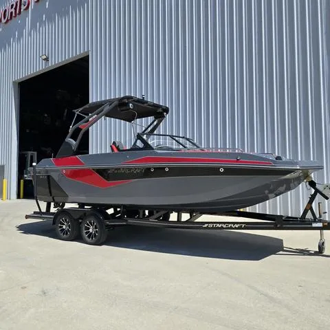 Slide: The Image of 2024 Starcraft MVX IO SURF boat on trailer outside a large building. - 3