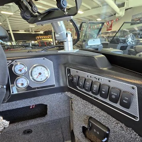 Slide: The Image of 2025 Lund 1875 Impact XS boat dashboard with gauges and control switches. - 10