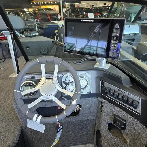 Slide: The Image of 2025 Lund 1875 Impact XS boat dashboard with steering wheel and Humminbird navigation system. - 8