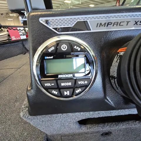 Slide: The Image of 2025 Lund 1875 Impact XS boat audio system with Kicker controls in a showroom. - 9