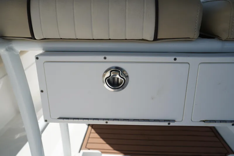 Slide: The Image of 2016 Sea Fox 246 Commander storage compartment with cushioned seating and stainless steel handle. - 13