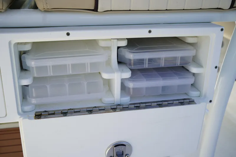 Slide: The Image of Storage compartment with plastic containers on a 2016 Sea Fox 246 Commander boat. - 15
