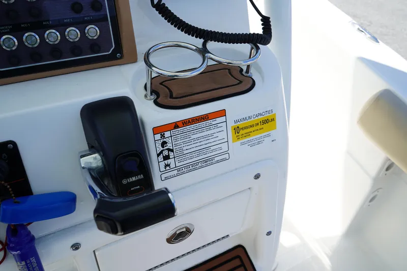 Slide: The Image of Control panel of 2016 Sea Fox 246 Commander boat with warning labels and cup holders. - 30