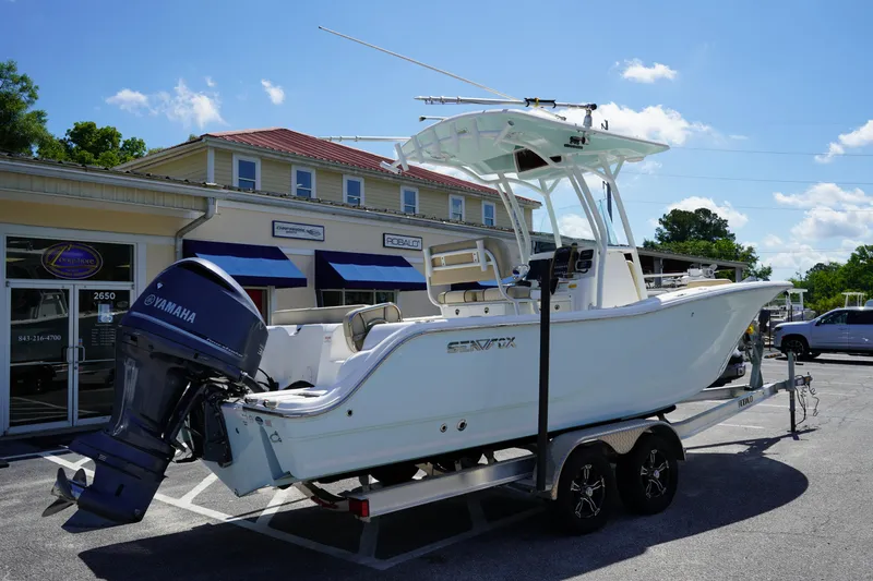 Slide: The Image of 2016 Sea Fox 246 Commander boat on trailer, parked outside a building under a clear blue sky. - 8