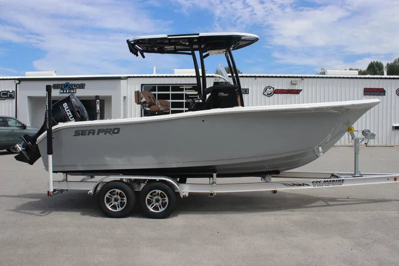 Slide: The Image of 2025 Sea Pro 222 boat on trailer, parked outside a marine dealership. - 2