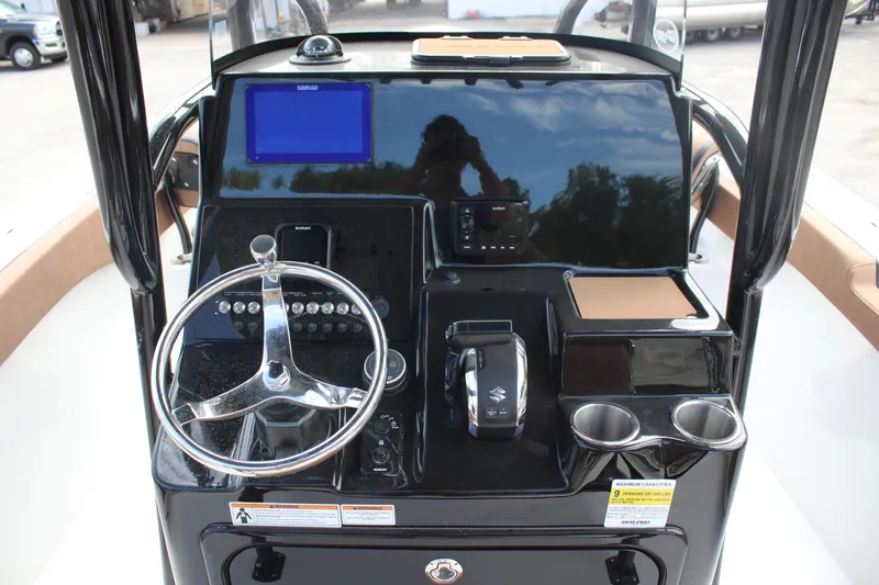 Slide: The Image of 2025 Sea Pro 222 boat dashboard with steering wheel, controls, and navigation screen. - 22