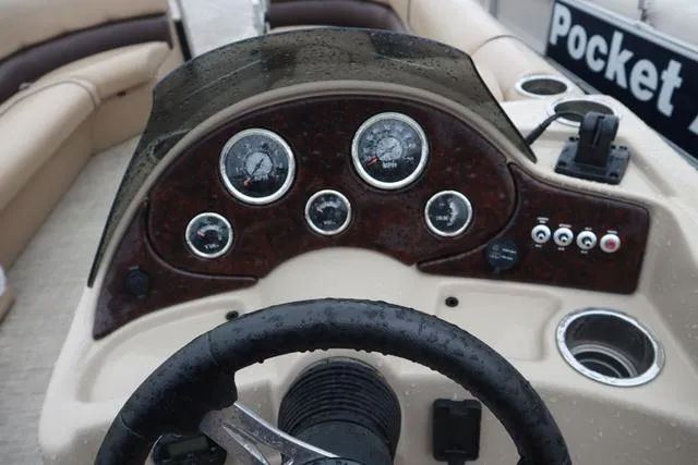 Slide: The Image of 2017 Lowe SF 232 boat dashboard with gauges and controls, wet from rain. - 10