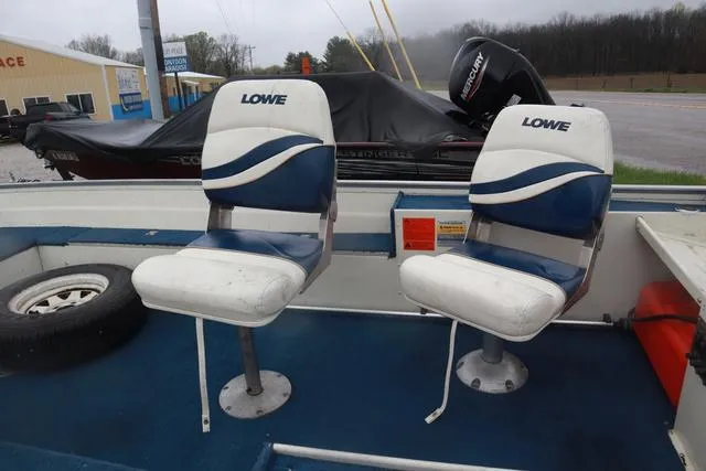 Slide: The Image of 1999 Lowe Sea Nymph 160 BT boat interior with two blue and white seats. - 11