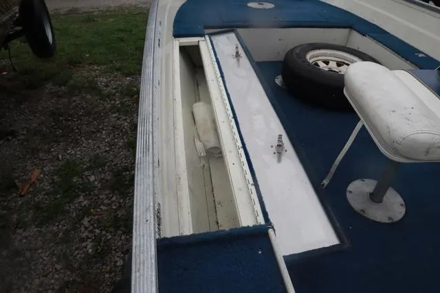 Slide: The Image of 1999 Lowe Sea Nymph 160 BT boat interior with storage compartment and spare tire. - 14