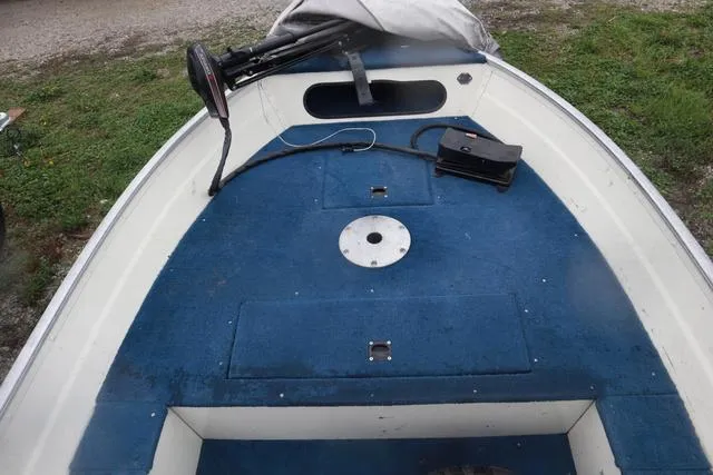 Slide: The Image of 1999 Lowe Sea Nymph 160 BT boat interior with blue carpet and storage compartments. - 16