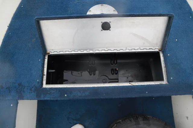Slide: The Image of Open storage compartment on 1999 Lowe Sea Nymph 160 BT boat with blue carpet. - 17