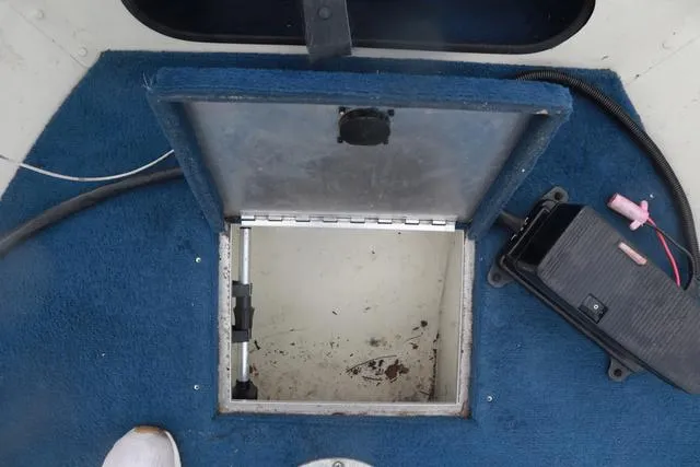 Slide: The Image of Open storage compartment on 1999 Lowe Sea Nymph 160 BT boat with blue carpet interior. - 18