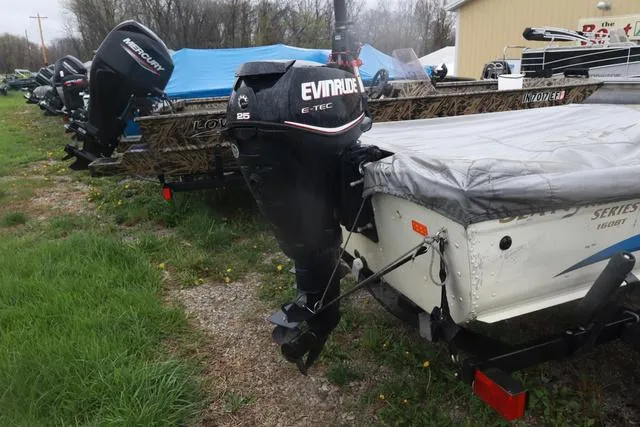 Slide: The Image of 1999 Lowe Sea Nymph 160 BT boat with Evinrude outboard motor, parked outdoors. - 6