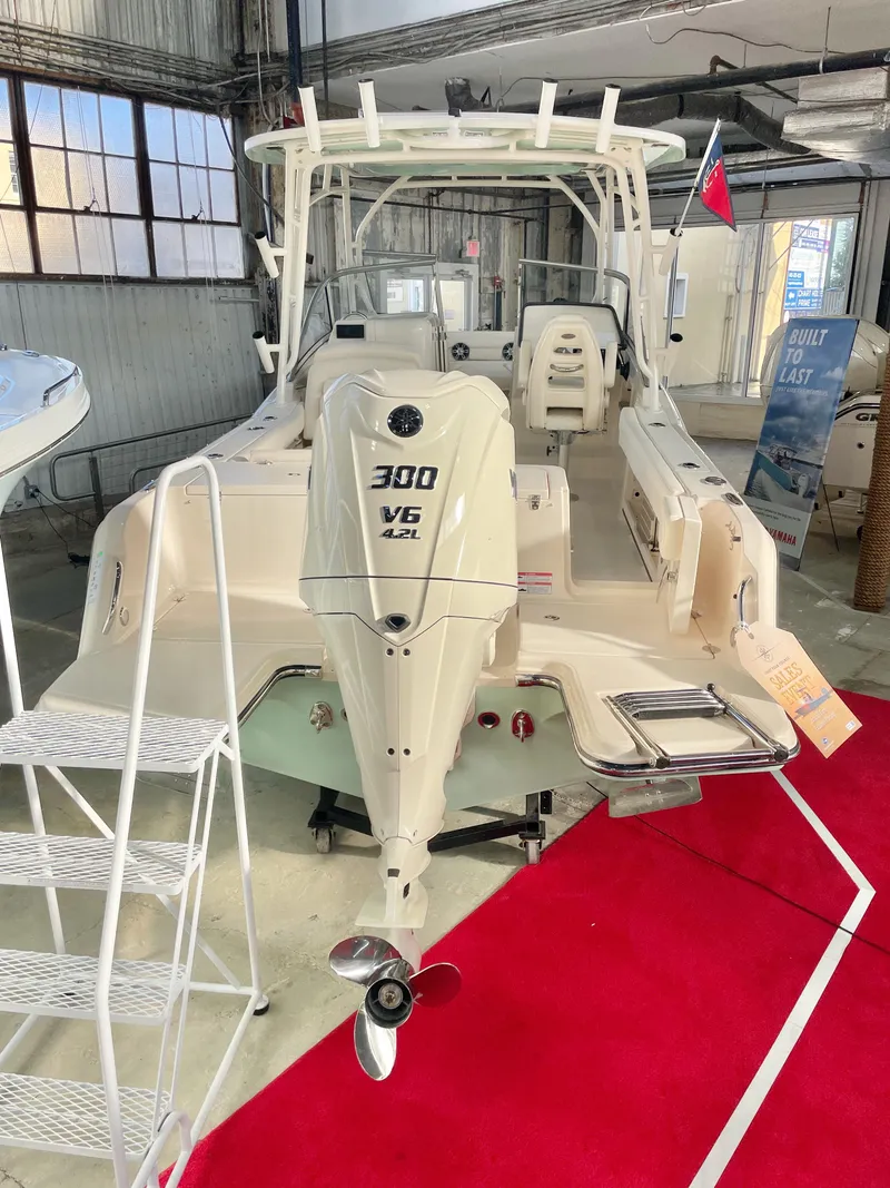 Slide: The Image of 2025 Grady-White Freedom 235 boat with 300 V6 engine displayed indoors. - 3