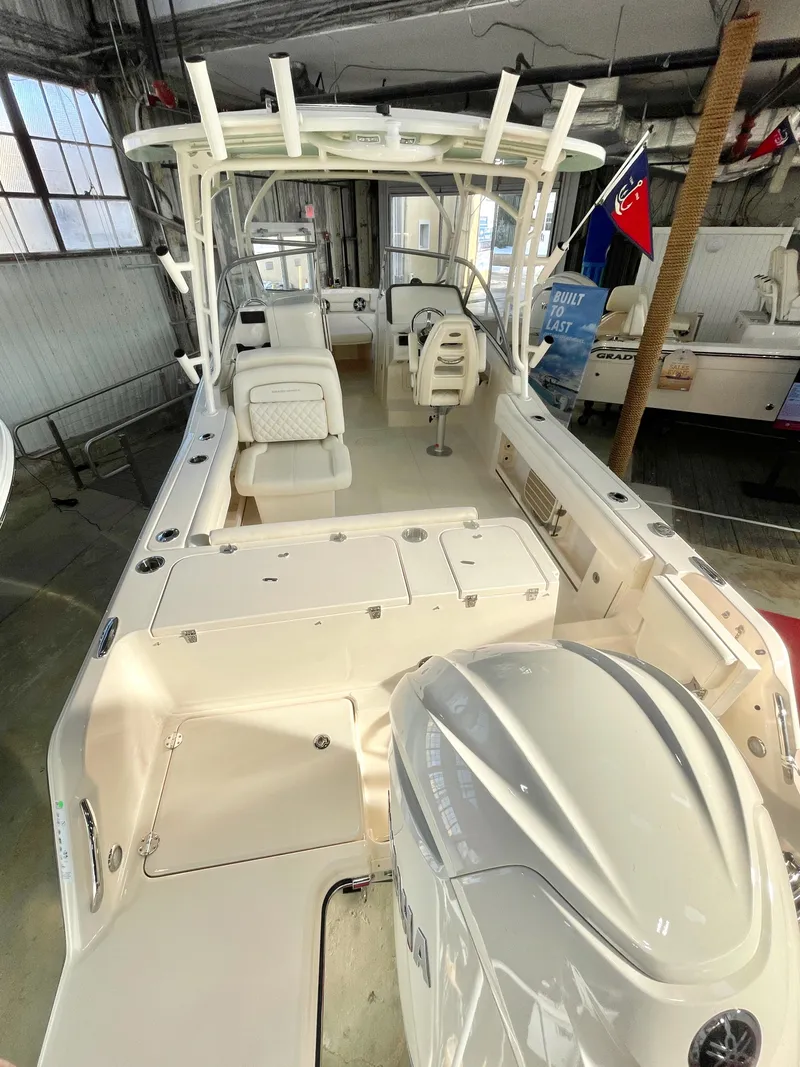 Slide: The Image of 2025 Grady-White Freedom 235 boat interior with seating and motor in a showroom. - 4