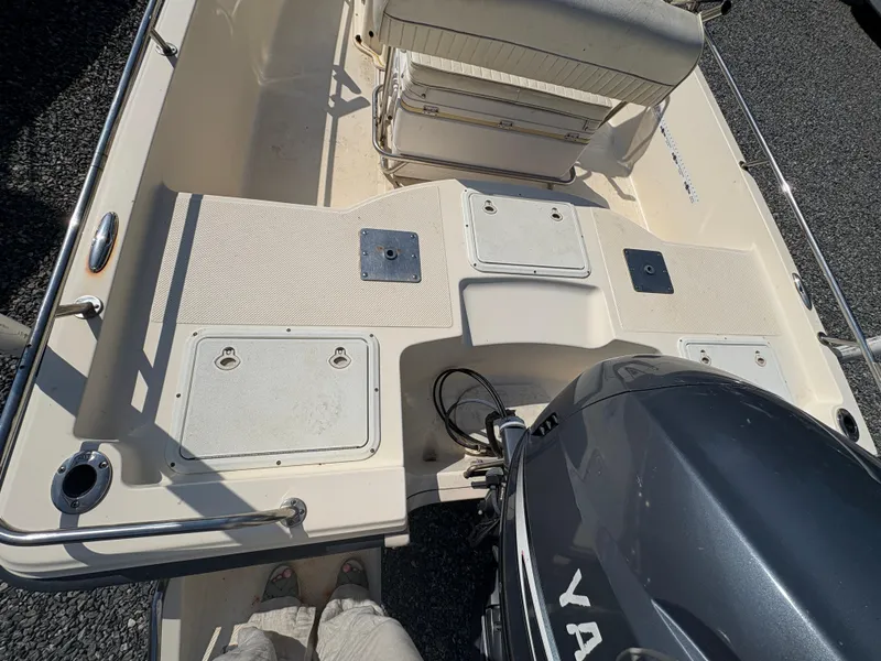 Slide: The Image of 2004 Key West 186 Bay Reef boat interior with Yamaha engine, featuring seating and storage compartments. - 11