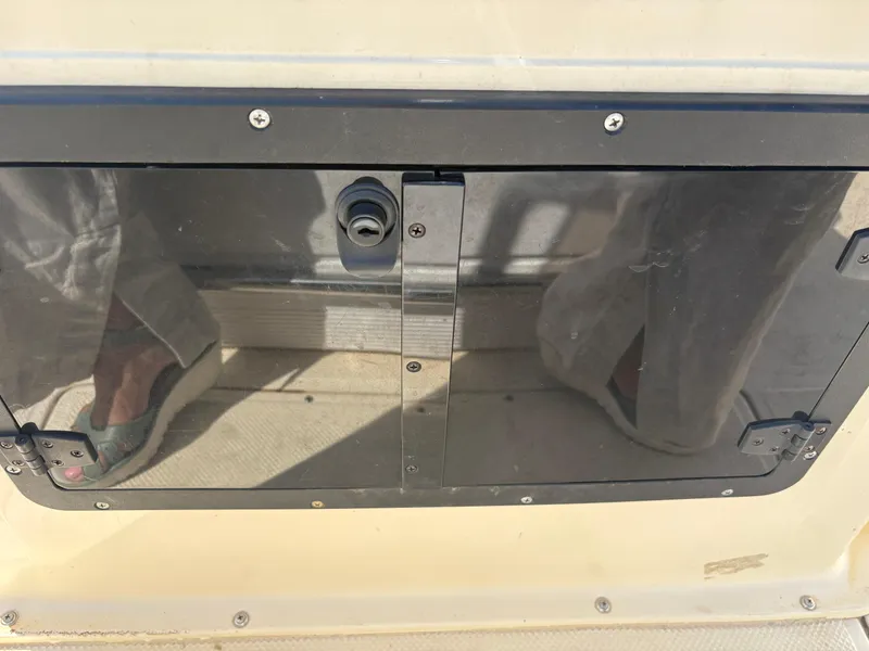 Slide: The Image of Key West 186 Bay Reef 2004 boat compartment with reflective cover and visible screws. - 15