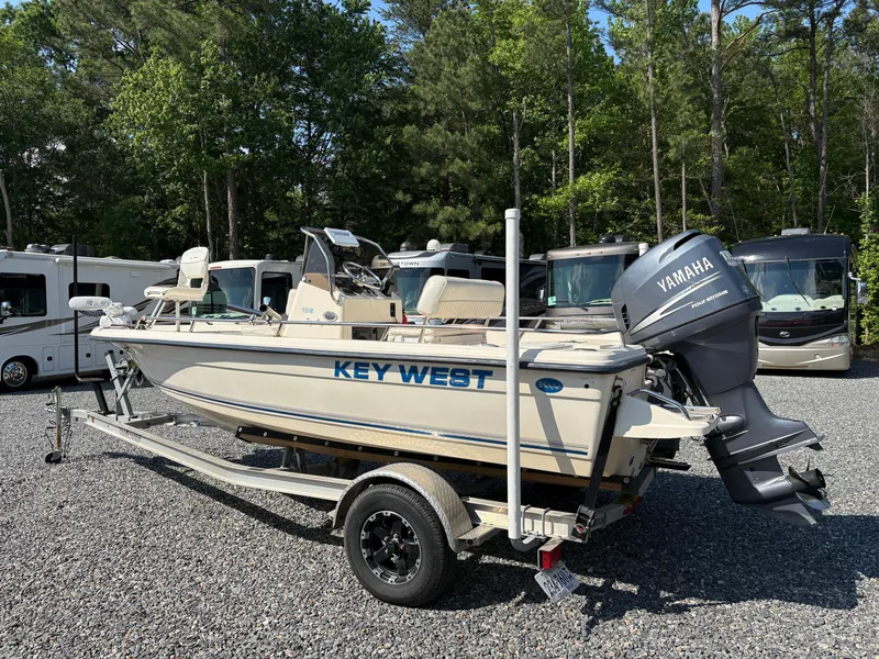 Slide: The Image of 2004 Key West 186 Bay Reef boat on trailer, parked outdoors near RVs. - 3
