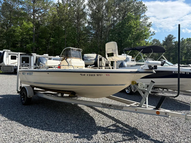 Slide: The Image of 2004 Key West 186 Bay Reef boat on trailer, parked in a lot with trees. - 6