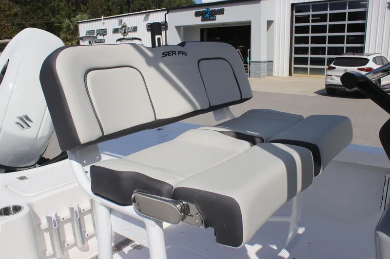Slide: The Image of 2025 Sea Pro 230 Bay boat seat, gray upholstery, outdoor dealership setting. - 14