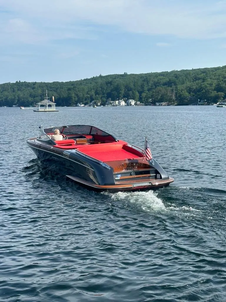 Slide: The Image of 2013 Riva Aquariva 33 cruising on a serene lake with lush green shoreline. - 10